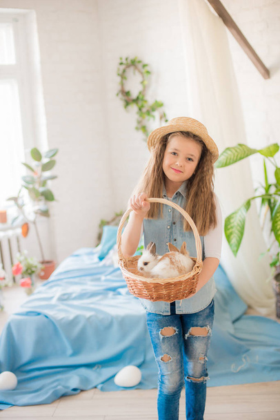 Cute girl with easter bunnies in the room decorative for the holiday. Easter mood - Valokuva, kuva