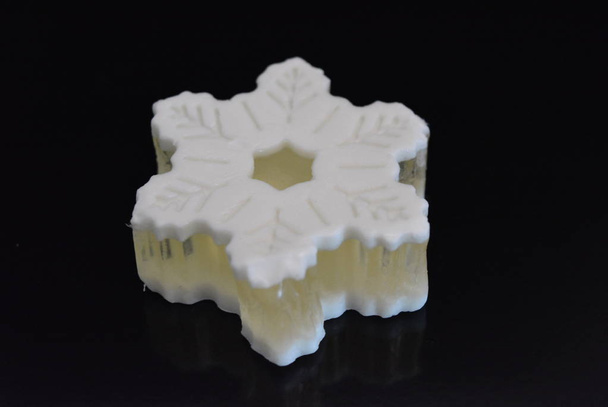 Gyönyörű fehér kézműves illatos szappan formájában egy nagy hópehely feküdt egy fekete fényes felület. - Fotó, kép