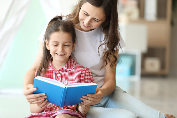 Carino bambina e sua sorella maggiore lettura libro a casa
 - Foto, immagini