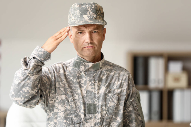 Saluting mature male soldier in headquarters building - Photo, Image