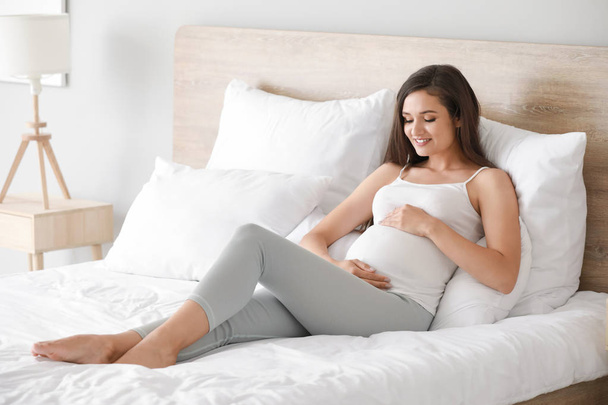 Красивая беременная женщина в спальне
 - Фото, изображение