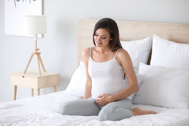 Beautiful young pregnant woman in bedroom - Valokuva, kuva