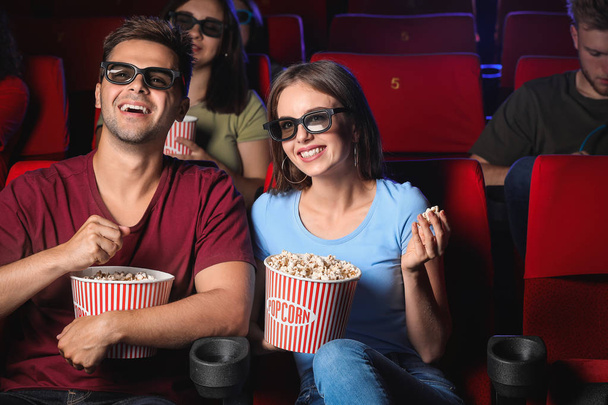 Couple with popcorn watching movie in cinema - Photo, image