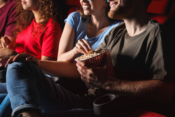Friends with popcorn watching movie in cinema - Photo, Image
