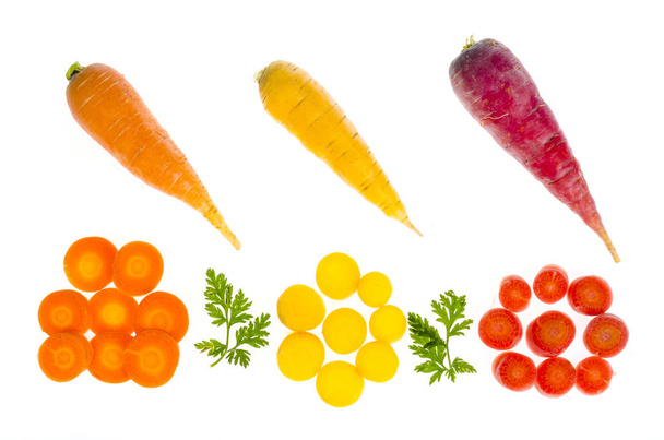 Pièces de carottes crues colorées sur fond blanc
 - Photo, image