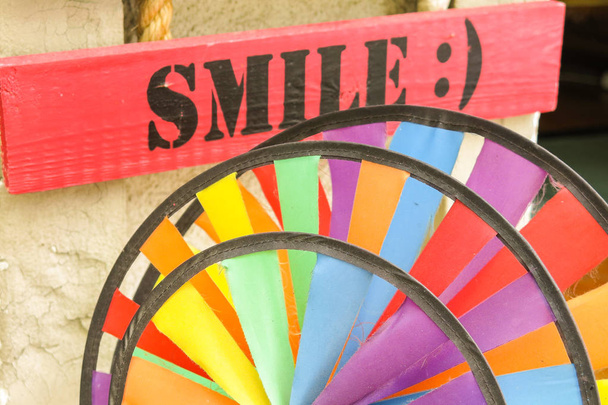 Teken met het woord glimlach. Het is altijd goed om te glimlachen, zelfs als een bord vol met kleuren je vertelt - Foto, afbeelding