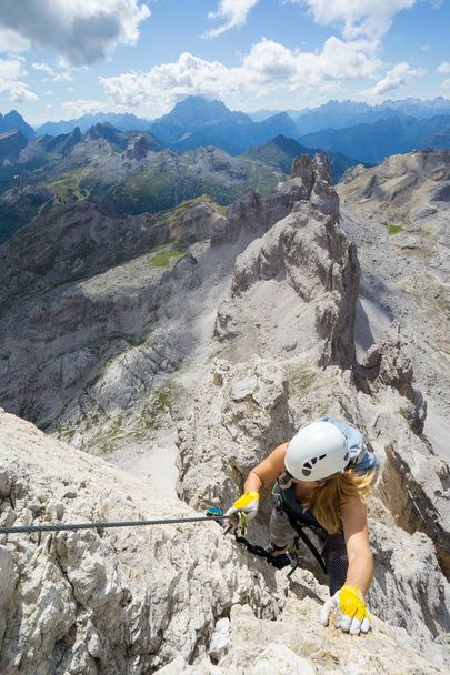 attraktive Bergsteigerin auf einem steilen Klettersteig in der italienischen  - Foto, Bild