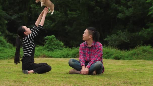 Onnelliset nuoret koiranpennun kanssa ulkona, hidastettuna
 - Materiaali, video