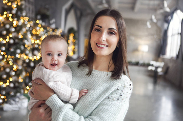 Όμορφη ευτυχισμένη μητέρα με λειψε μικρά κόρη σε δεμένη πουλόβερ  - Φωτογραφία, εικόνα