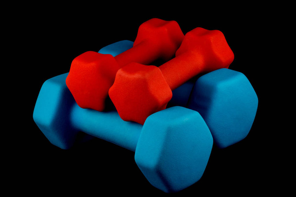 Niebieskie i czerwone dumbells na czarnym tle - Zdjęcie, obraz
