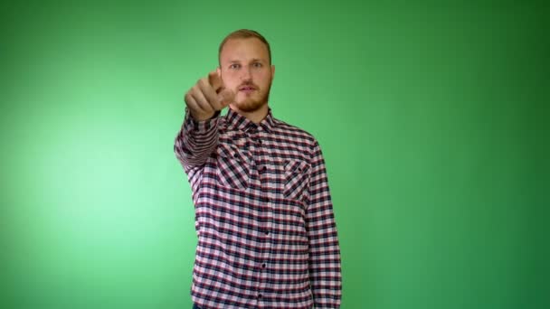 Bearded young man. Plaid shirt. Pointing finger at someone. - Footage, Video