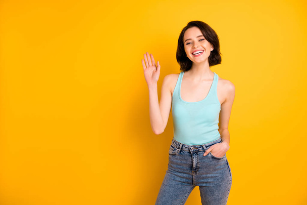Photo of cute nice charming beautiful careless girl saying hi to you while isolated over vivid yellow background - Foto, immagini