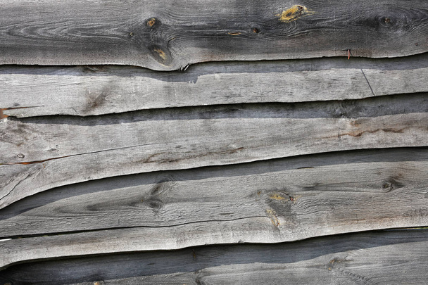 Yıpranmış eski gri tahtalardan yapılmış ahşap bir çit. - Fotoğraf, Görsel
