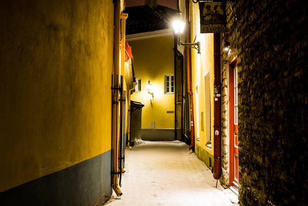 Snow-covered empty street at night. Old Town of Tallinn, Estonia - Фото, зображення