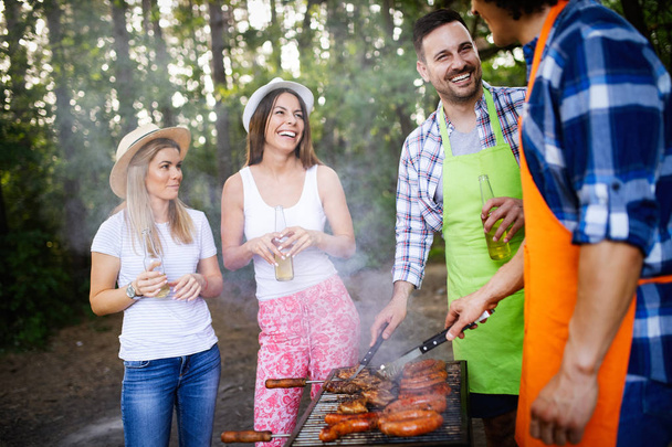 Friends having a barbecue party in nature while having fun - Photo, image