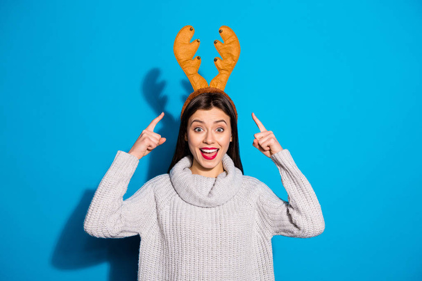 Photo of pretty lady indicating on her head wearing toy horns knitted pullover isolated blue background - Foto, immagini