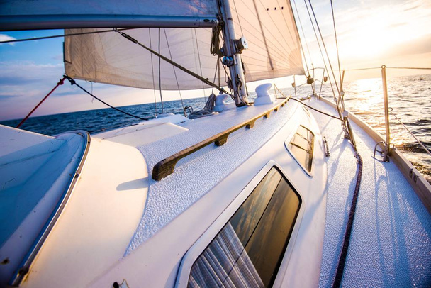 Segeln bei Sonnenuntergang. Blick vom Deck der Jacht auf Bug und Segel. Nahaufnahme. Ostsee, Lettland - Foto, Bild