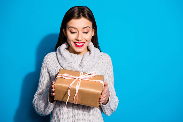 Portrait of charming lady getting present looking smiling wearing gray sweater isolated over blue background - Foto, Imagem