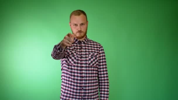 Bearded young man. Plaid shirt. Pointing a finger at someone and holding his throat. - Footage, Video