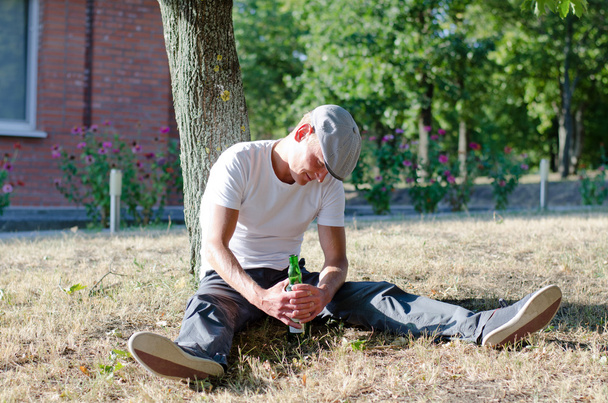 Drunk man clutching a bottle of alcohol - Photo, Image