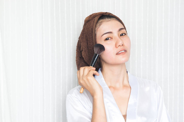 Belle femme asiatique tenant brosse de maquillage. Concept de beauté
 - Photo, image