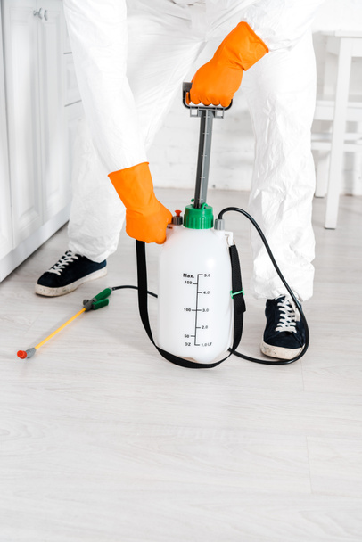 cropped view of man in uniform touching toxic equipment in kitchen  - Photo, Image
