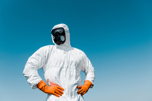 exterminator in protective mask and uniform standing with hands on hips  - Photo, Image