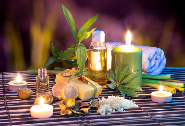Lemon soap , oil, towel, salt, bamboo, and candles in garden - Photo, Image