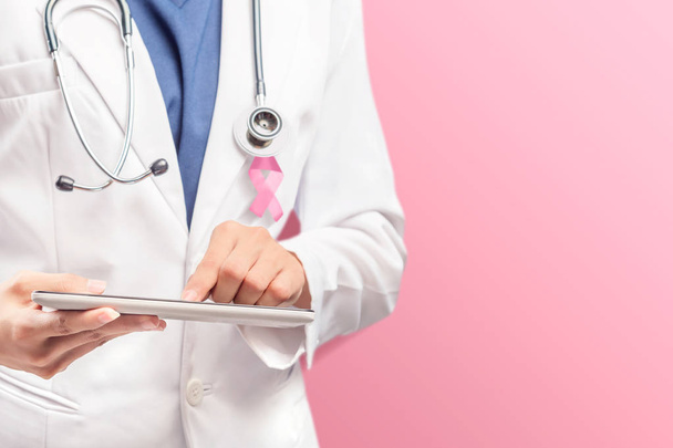 A woman doctor in a white lab coat with a pink ribbon and a stet - Foto, Imagen