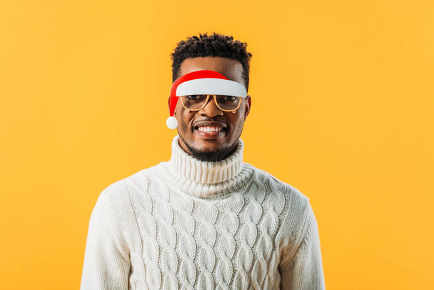 Hombre afroamericano en jersey de invierno y gafas de Navidad aisladas en amarillo
 - Foto, imagen