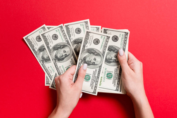 von oben betrachtet weibliche Hände, die Geld zählen. Hundert-Dollar-Banknoten auf buntem Hintergrund. Gehaltskonzept. Schmiergeld-Konzept - Foto, Bild
