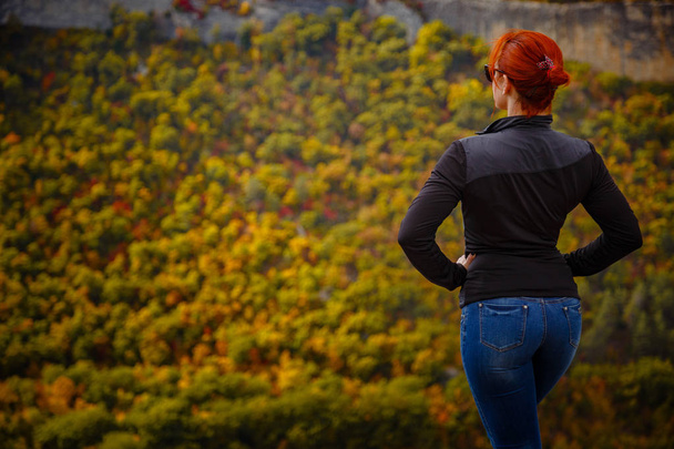 Senhora elegante de cabelos vermelhos com olhos fechados descansando na natureza nas montanhas no prado
 - Foto, Imagem