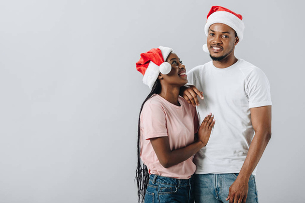 Afro-amerikai házaspár Santa kalap izolált szürke - Fotó, kép