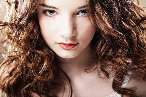 Beautiful young woman with curly hair. - 写真・画像