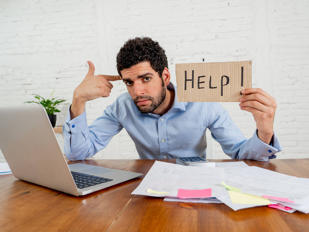 Young overwhelmed entrepreneur needing help paying off debts and bills in Small business financial problems. Worried desperate young man feeling stressed working through finances at home office. - Fotoğraf, Görsel