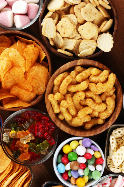 Zoute snacks. Pretzels, chips, crackers en snoep zoetigheden op Tabl - Foto, afbeelding