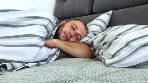 L'uomo sta dormendo da solo nel letto sotto la coperta. Vista laterale
. - Filmati, video