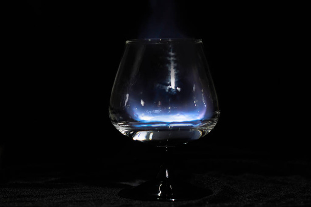 Cognac glass with a burning sambuca on a black background - Photo, image