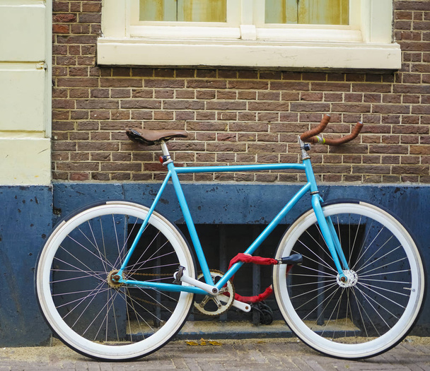 sporty old style blue bicycle on brown and white wall background. blue and brown bicycle parked  exterior. red brick wall background - Φωτογραφία, εικόνα