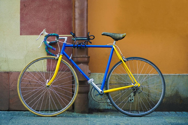 beautiful old style blue bicycle on brown and orange wall background. blue and yellow bicycle parked  exterior. cement  wall background - Valokuva, kuva