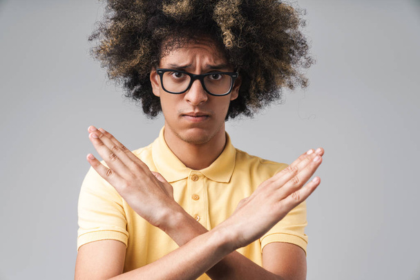 Photo of displeased caucasian man with afro hairstyle keeping ar - Photo, Image
