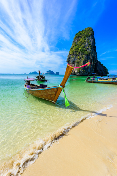 Пляж Ао Пхра Нанг (Ao Phra Nang Beach) - традиционная тайская деревянная длиннохвостая лодка на полуострове Рейлай перед известняковыми карстовыми скалами, недалеко от Ао Нанг, провинция Фаби, Андаманское море, Таиланд
 - Фото, изображение