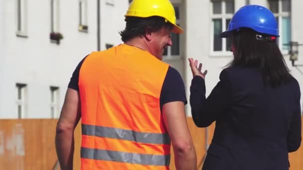 Πίσω γύρισε άνδρες και γυναίκες μηχανικοί περπάτημα στο εργοτάξιο - Πλάνα, βίντεο