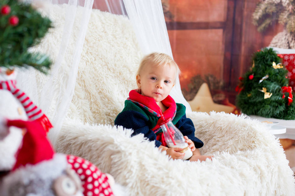 Baby boy, cute child, wearing santa claus robe sitting in rockin - Foto, Imagen