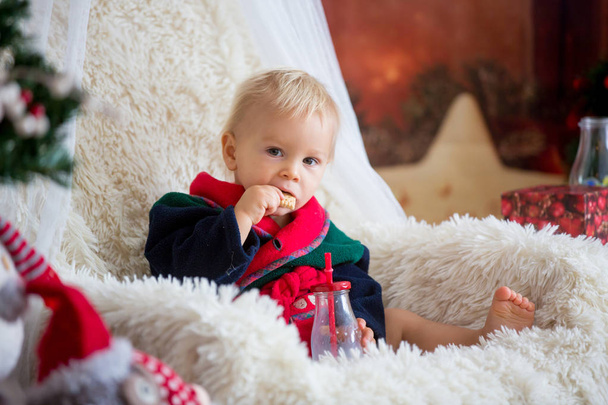 Baby boy, cute child, wearing santa claus robe sitting in rockin - Foto, Bild