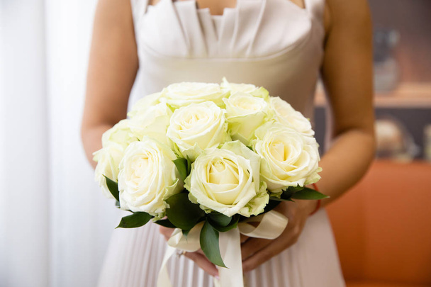Beautiful wedding bouquet of flowers in the hands of the bride - 写真・画像