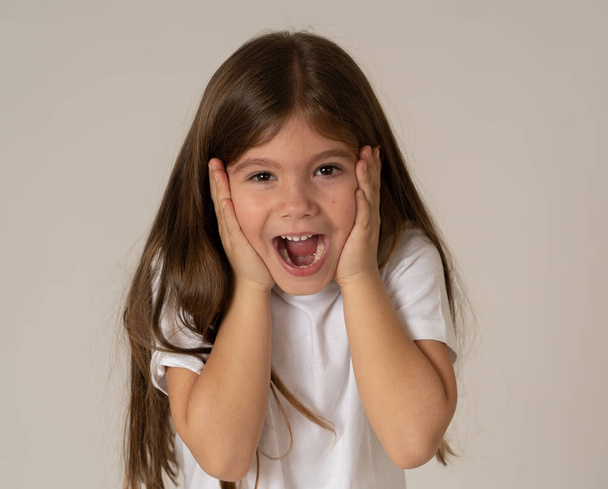 Portret van schattig gelukkig, opgewonden, grappig, vrolijke jonge jongen meisje met geschokt verbaasd gezicht horen goed en onverwacht nieuws. Bij kinderen en positieve menselijke emoties en uitdrukkingen. - Foto, afbeelding