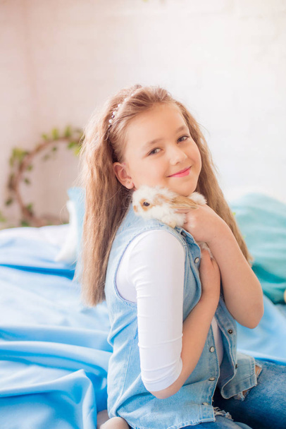 Cute girl with easter bunnies in the room decorative for the holiday. Easter mood - Photo, image