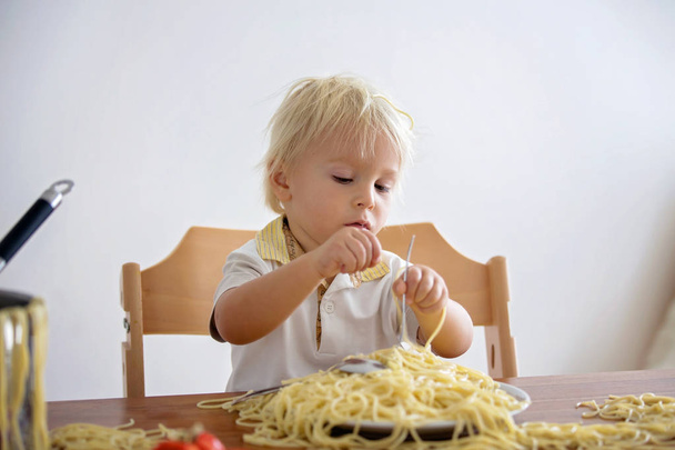 Little baby boy, toddler child, eating spaghetti for lunch and m - Fotó, kép