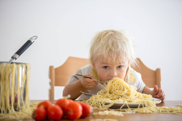 Little baby boy, toddler child, eating spaghetti for lunch and m - Fotó, kép